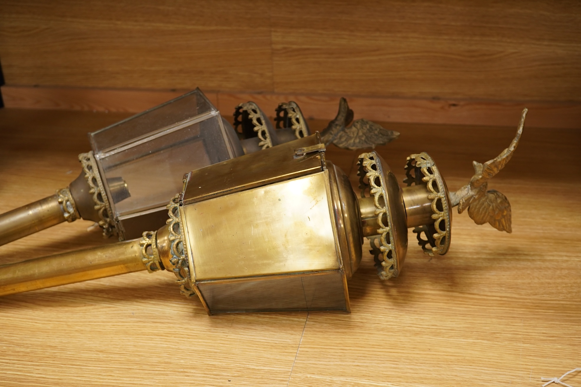 A pair of brass coaching lamps with eagle mounts, 75cm high